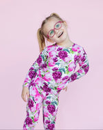 Child wearing a floral pajama on a pink background